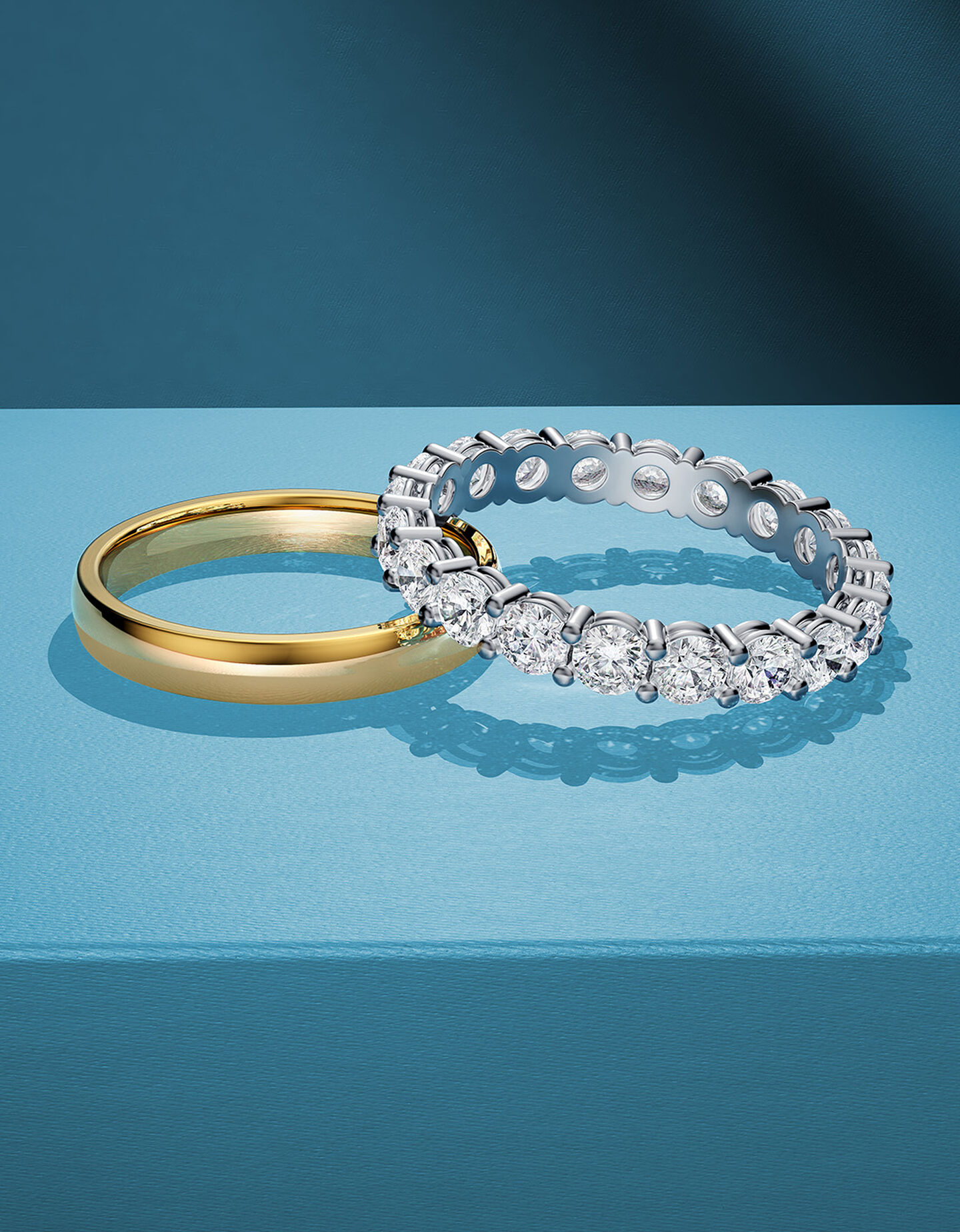 Two Birks wedding rings stacked on a blue background.
